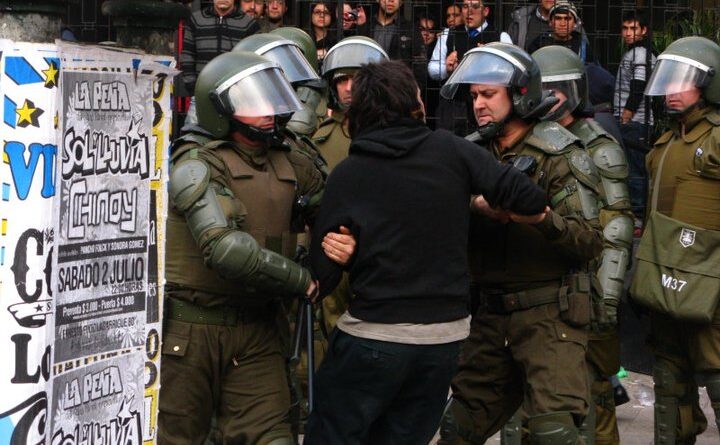 Fotografía documental de Carabineros trasladando a una persona durante una protesta estudiantil en Chile, 2011. Autor: Nicolás15, CC BY-SA 3.0.