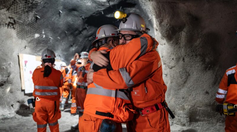 Dos personas con equipos de protección se abrazan en El Teniente durante el hito de Andes Norte en mayo de 2025. Fotografía de archivo publicada por El Tipógrafo; no corresponde a la emergencia de octubre de 2026.